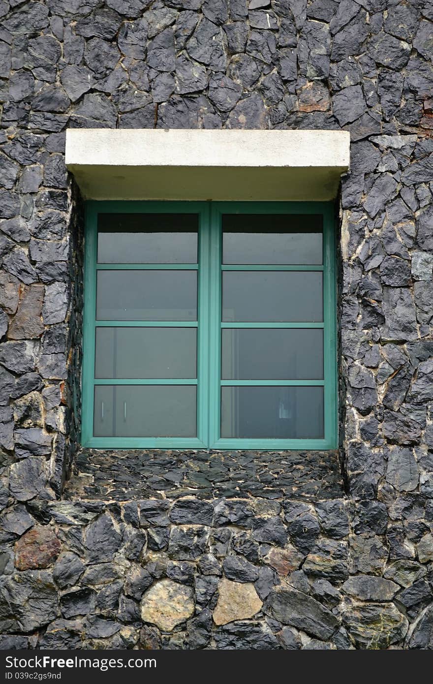 Green Window in black wall shuttered window on painted brick wall