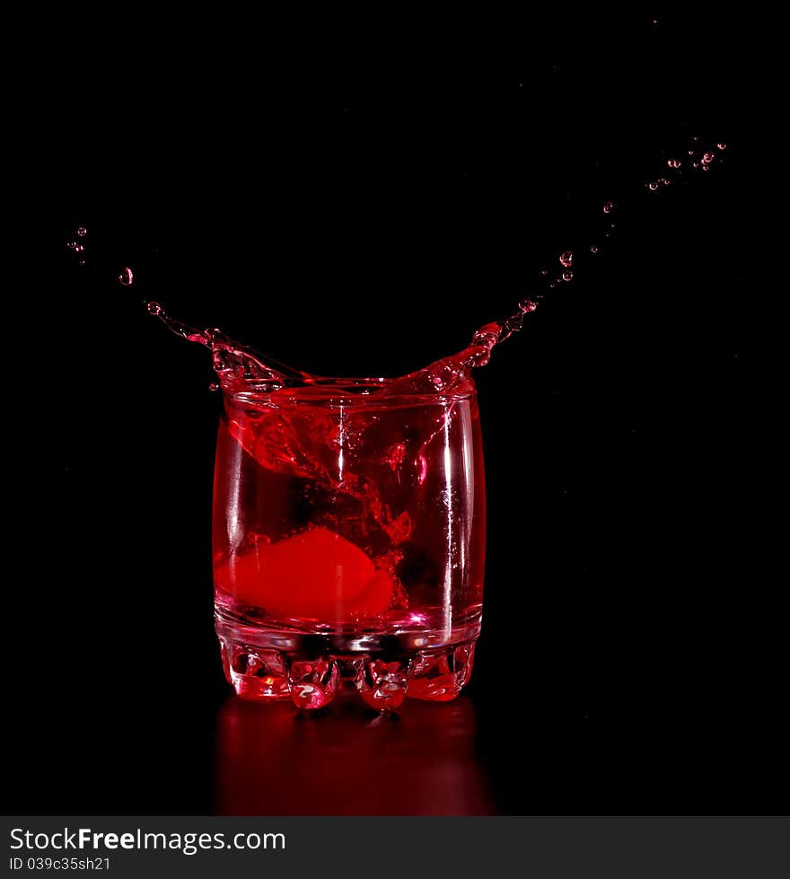 Orange in red water splash on black background