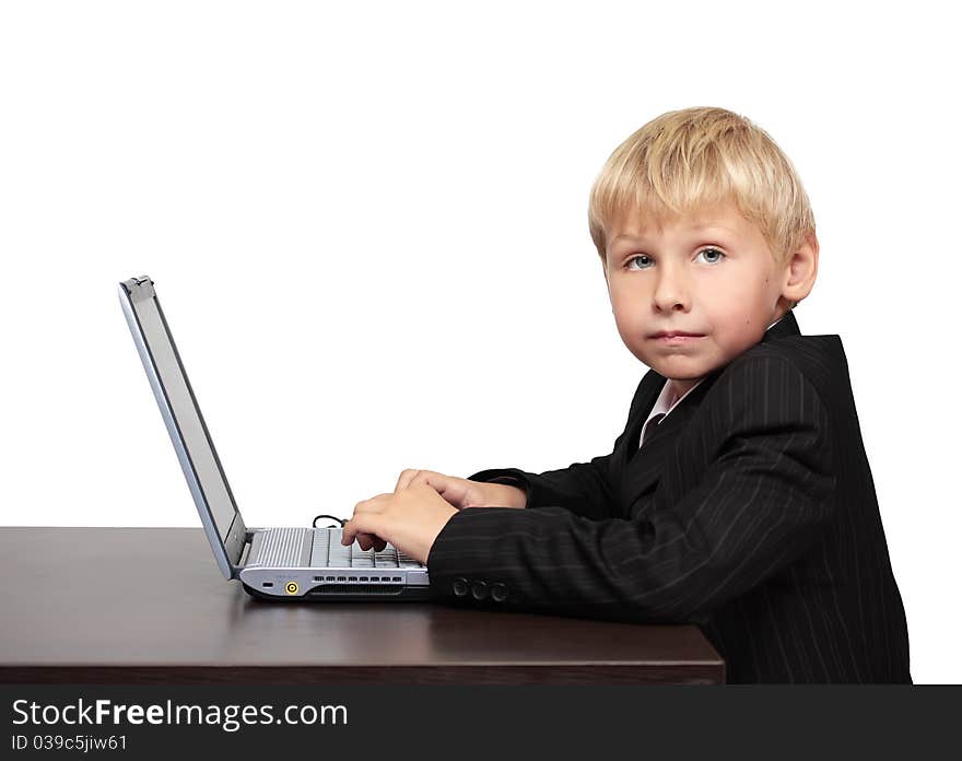 Boy in a suit sitting with a laptop. Boy in a suit sitting with a laptop