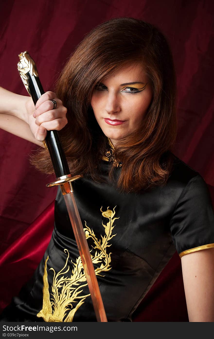 A woman dressed like a Giesha and Katana swords in her hands. close-up. A woman dressed like a Giesha and Katana swords in her hands. close-up.