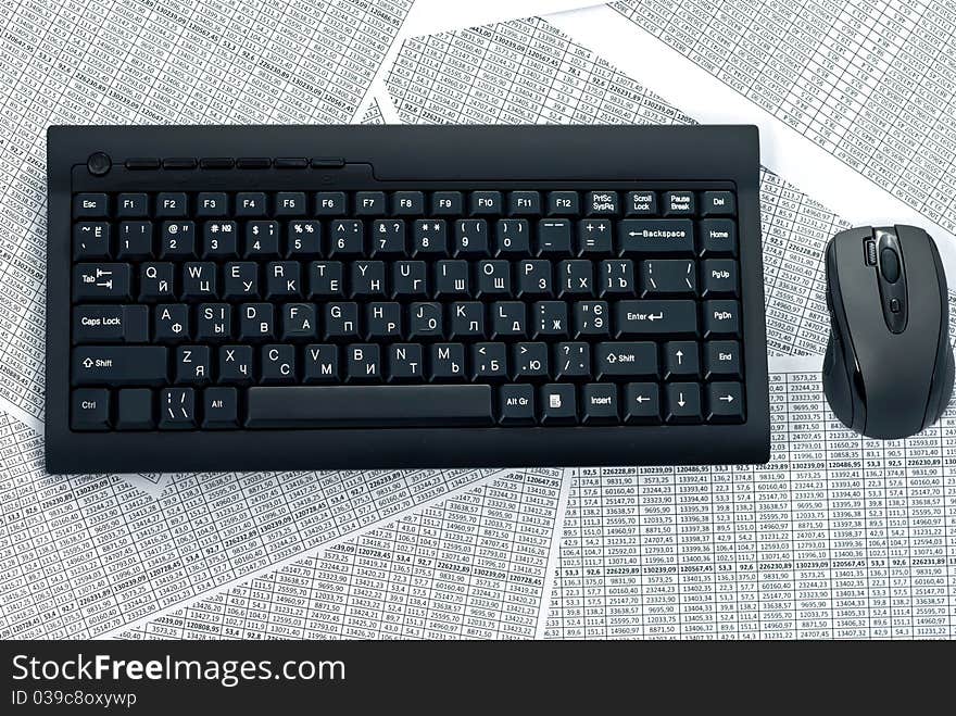 Black keyboard and mouse on a spreadsheets. Black keyboard and mouse on a spreadsheets.