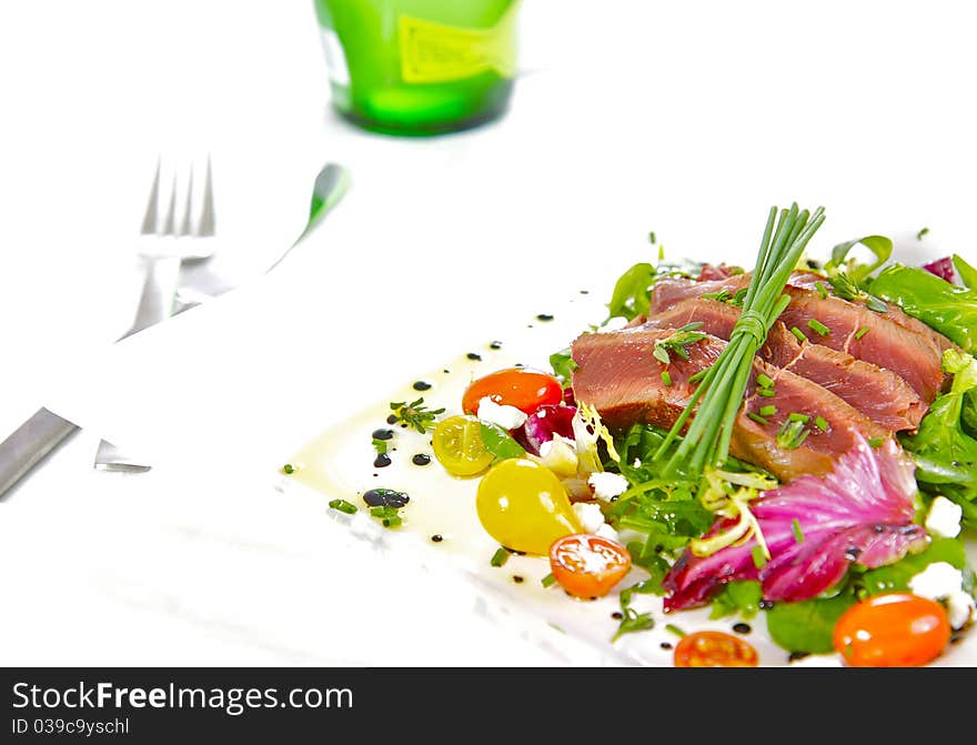 A prime cut of grilled, tender fillet beef on a healthy, and colourful herb salad. A prime cut of grilled, tender fillet beef on a healthy, and colourful herb salad.