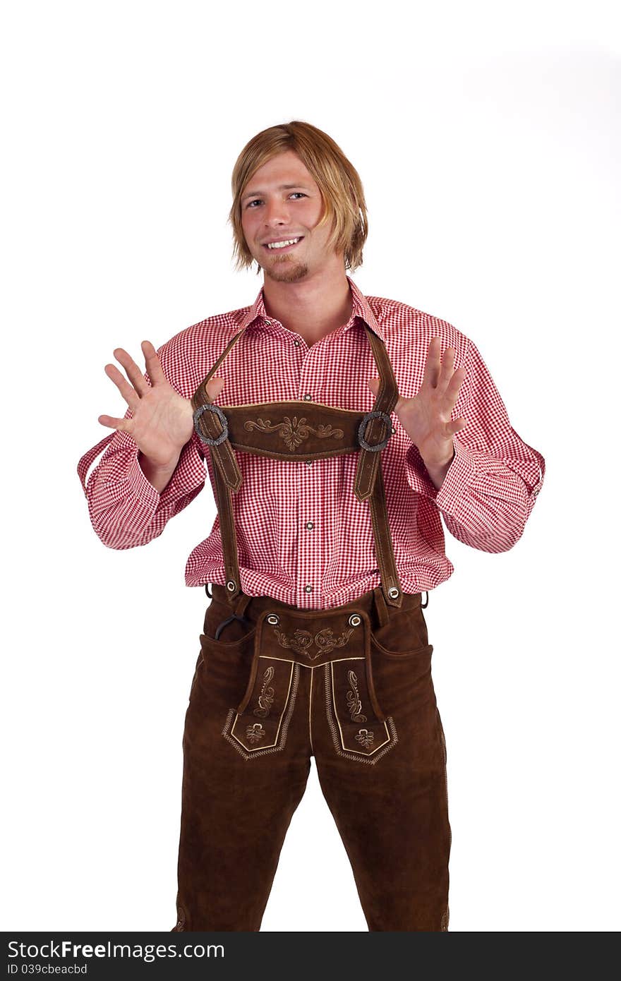 Bavarian man with oktoberfest leather trousers (lederhose) holds suspenders. Isolated on white background.