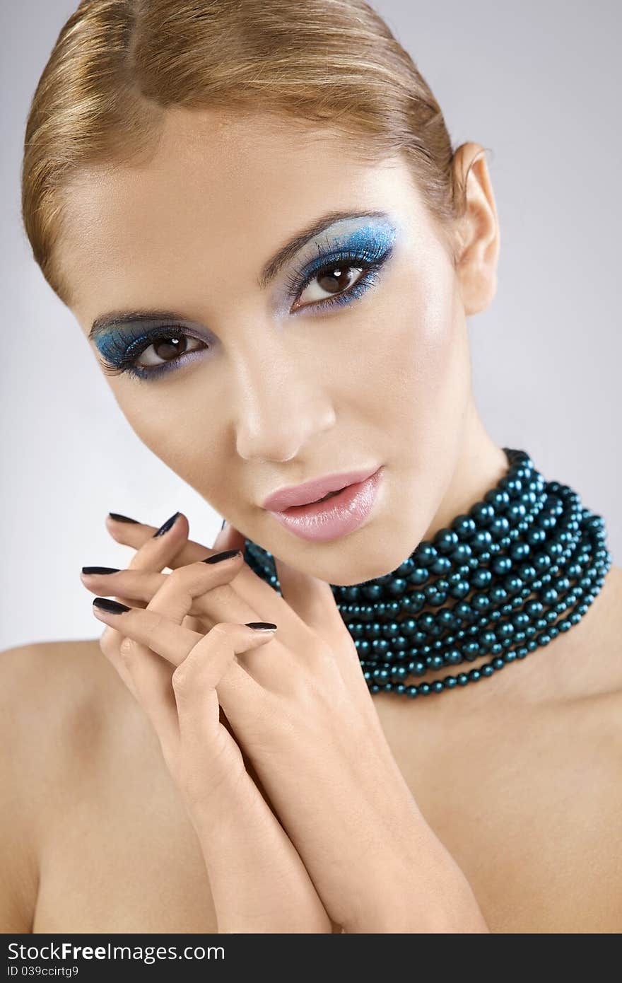 Beautiful young female face with bright fashion multicolored make-up and beauty black manicure of fingernails. Beautiful young female face with bright fashion multicolored make-up and beauty black manicure of fingernails