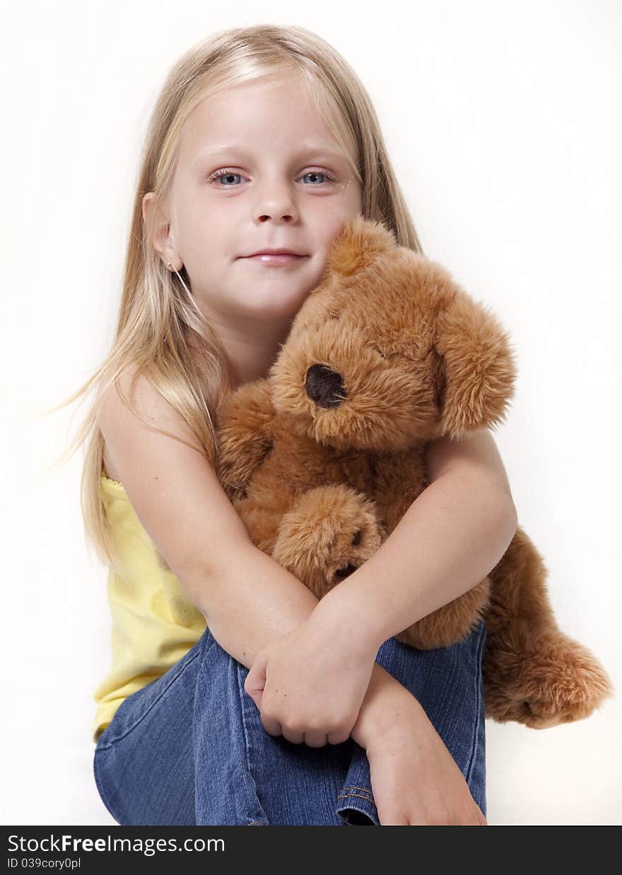 Little girl with teddy bear looking at camera with shy smile. Little girl with teddy bear looking at camera with shy smile