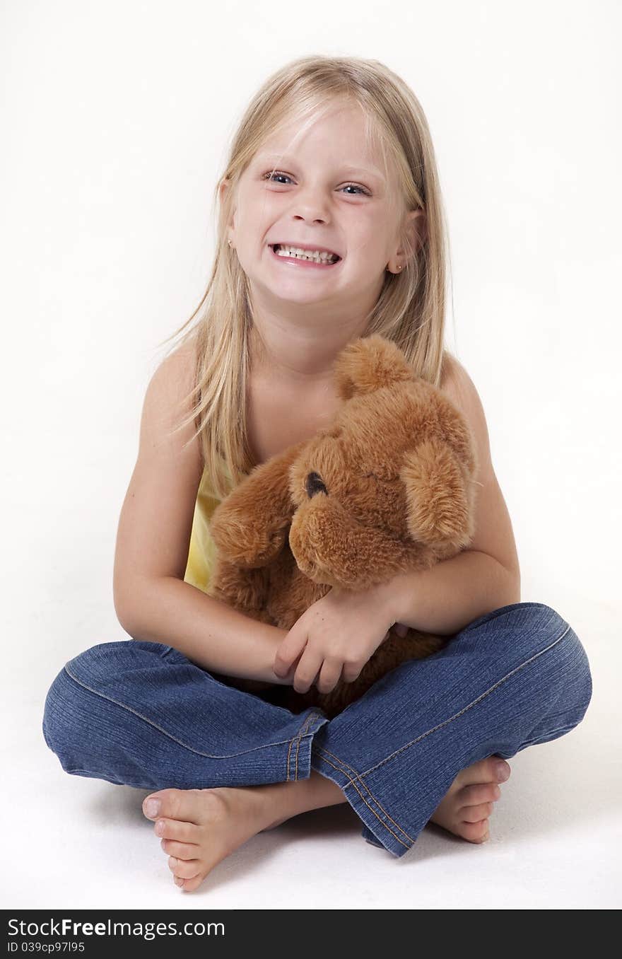 Little girl with a teddy bear smiling funny. Little girl with a teddy bear smiling funny