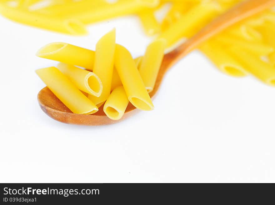 Penne and spoon isolated on white background