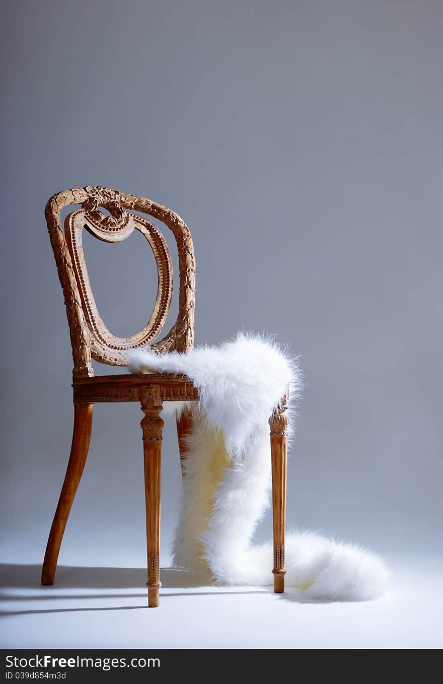 Old-fashioned wooden chair with white fur on it