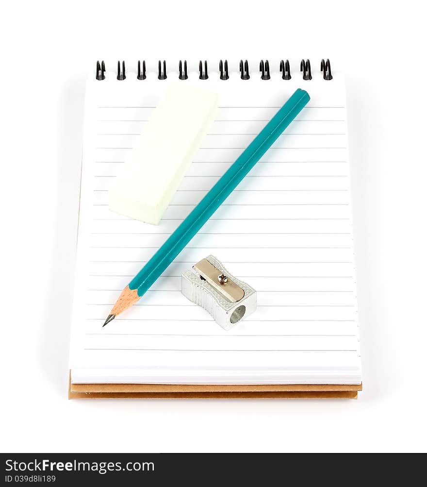 Pencil sharpener and eraser on a spiral notepad isolated on white background. Pencil sharpener and eraser on a spiral notepad isolated on white background