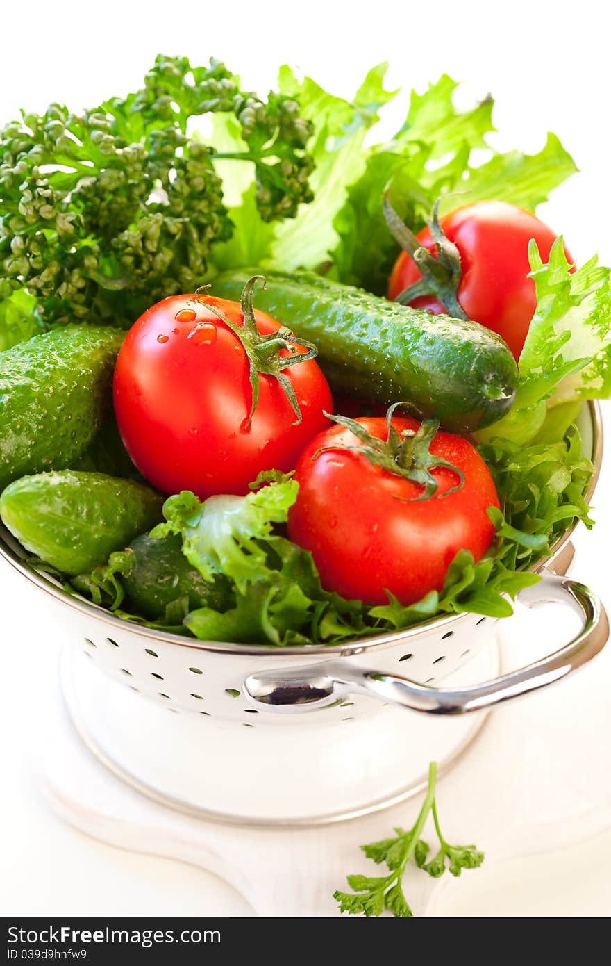 Tomatoes,cucumbers and Lettuce leaves in a colander. Tomatoes,cucumbers and Lettuce leaves in a colander