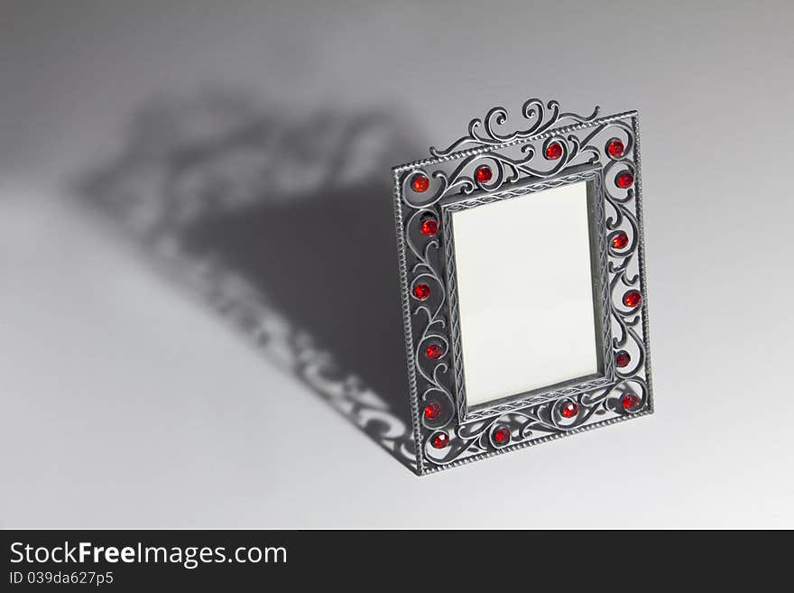 Empty photo frame with dramatic shadow on the table