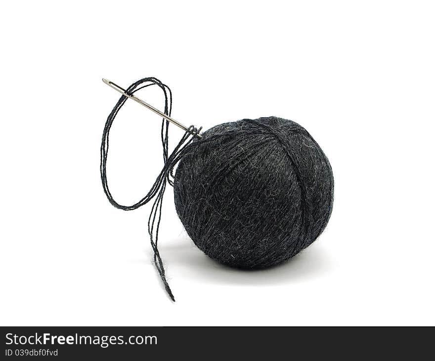 Black thread ball and needle on a white background