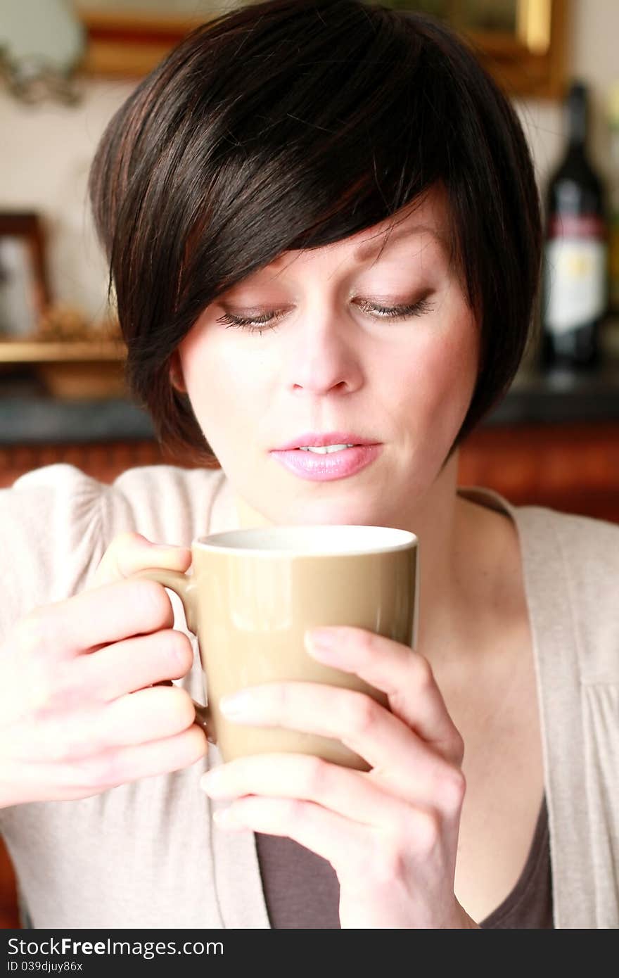 A young happy woman drinking coffee