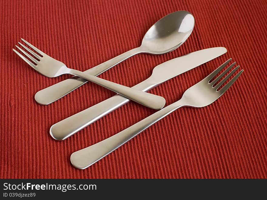 Set of flatware on red background top view