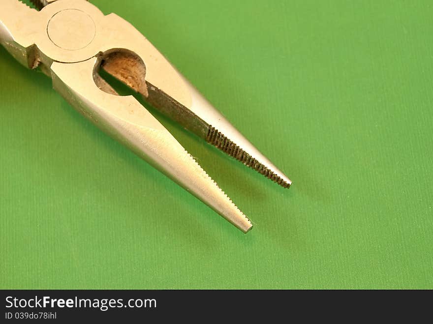 Pliers on a green background macro photography