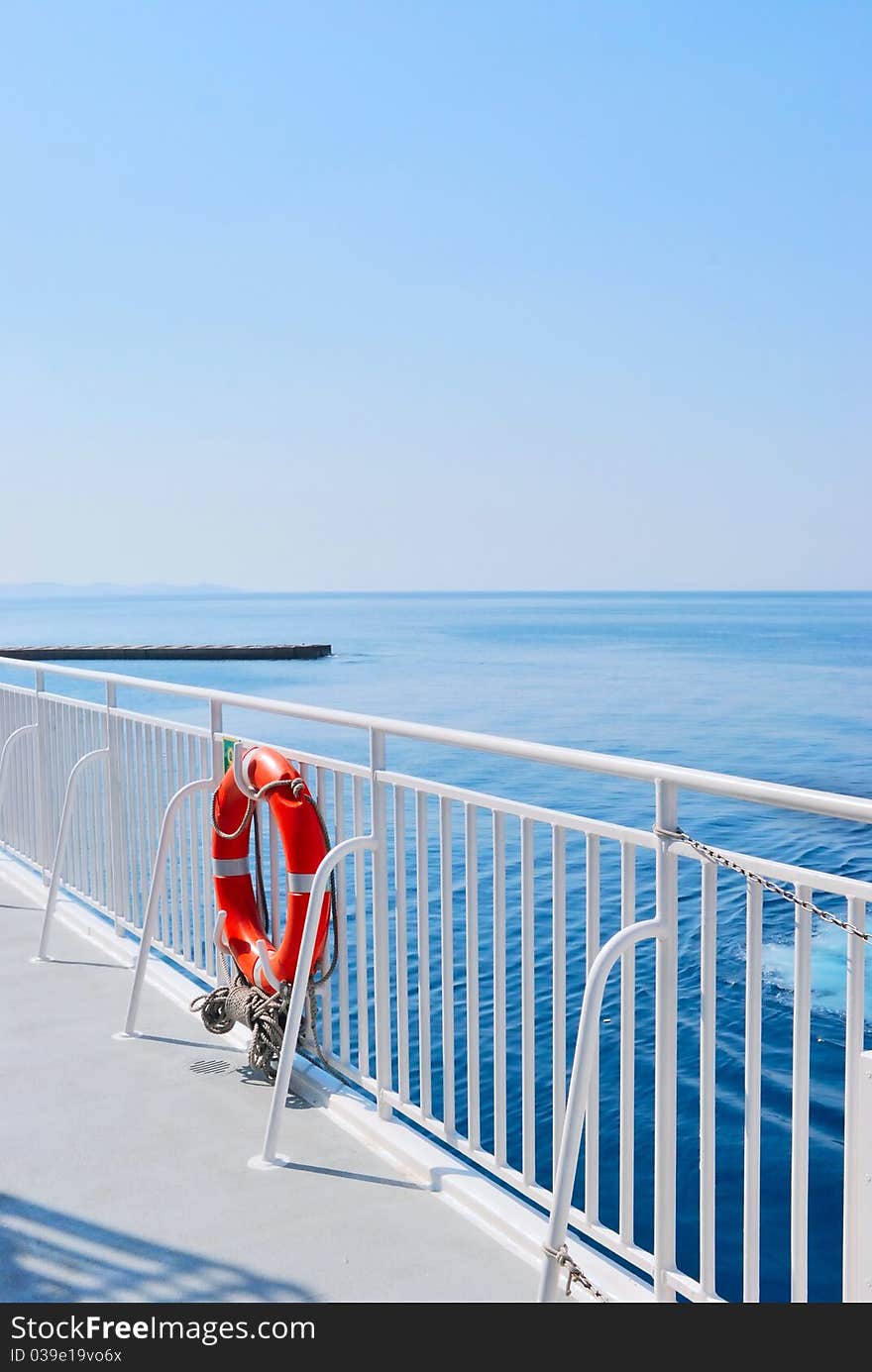 Red Lifebuoy In Front Of The Blue Sea