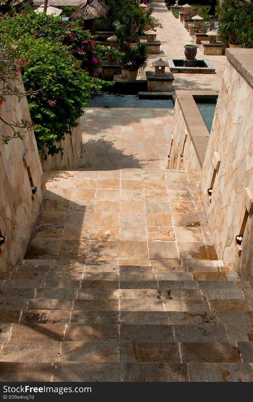 A directional natural granite stairway with outdoor fountain and lighting at a resort