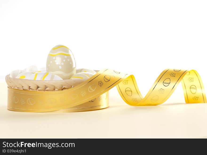 Easter egg in basket decorated with gold ribbon