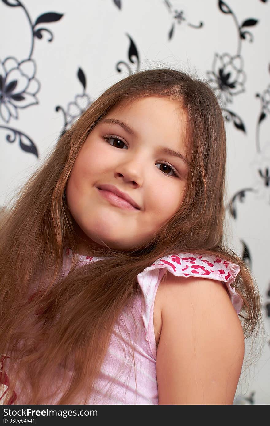 A happy little girl sitting on the sofa, smiling. A happy little girl sitting on the sofa, smiling