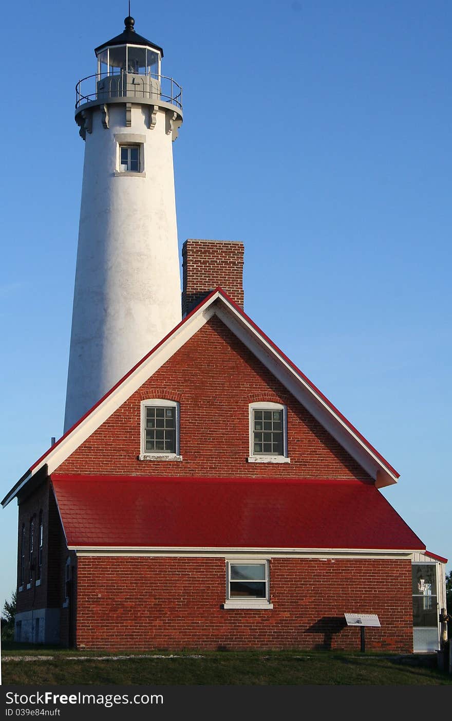 Tawas Point Lighthouse under bright blue sky. Tawas Point Lighthouse under bright blue sky