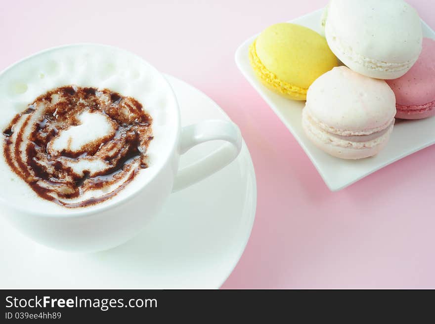 Cappuccino with macaroons on a pink background