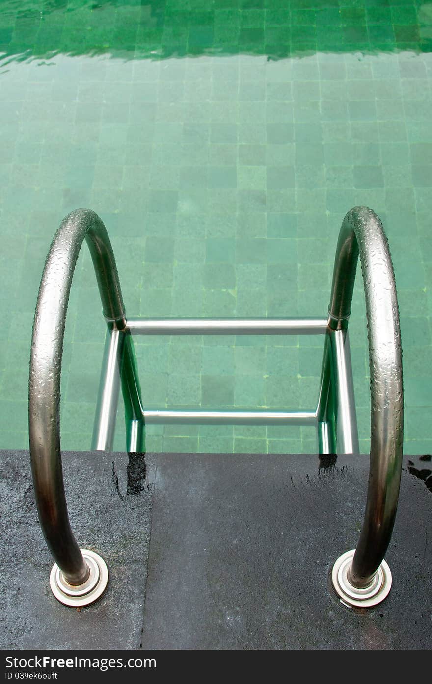 A stainless steel railing in a swimming pool