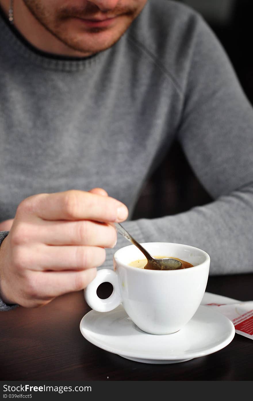 Man having morning coffee mixing it with spoon. Man having morning coffee mixing it with spoon