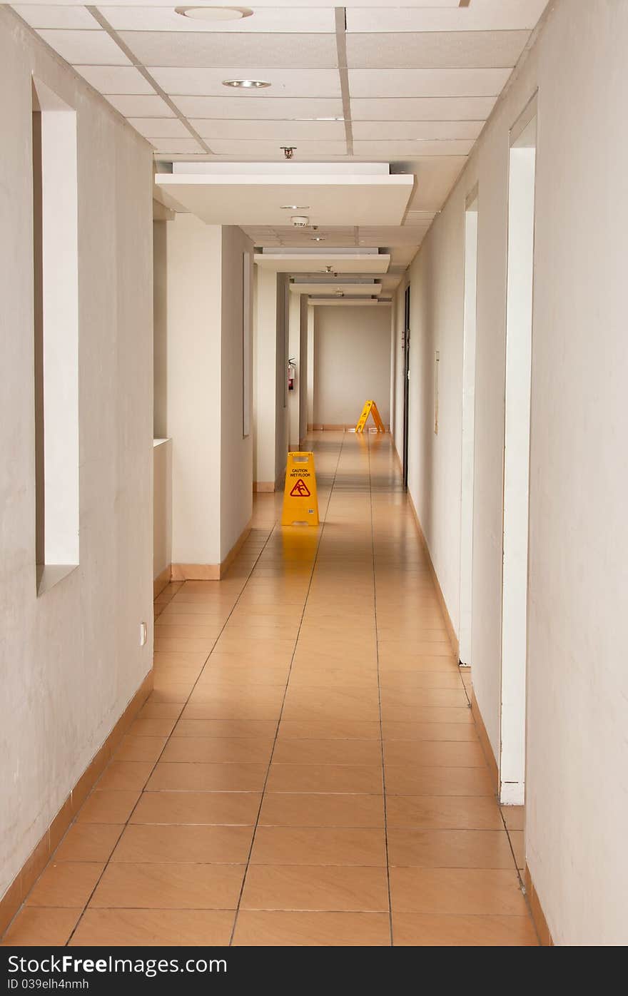 A narrow tunnel vision with a wet floor warning sign