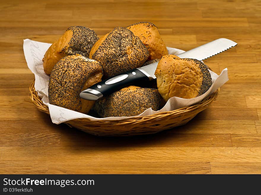 Fresh Bread Rolls and knife In Basket on wooden table. Fresh Bread Rolls and knife In Basket on wooden table