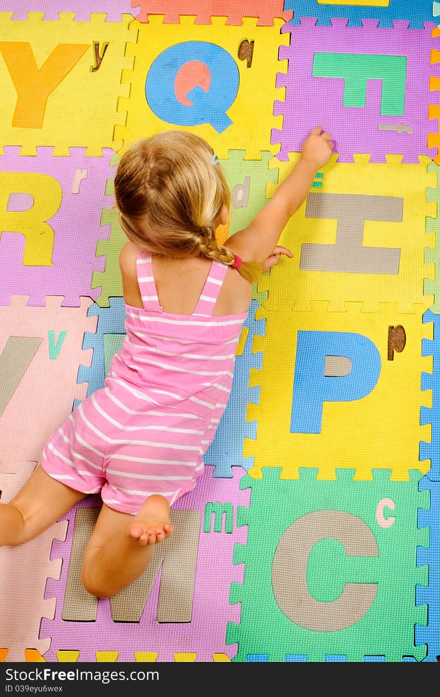 Cute toddler learns the alphabet in playschool. Cute toddler learns the alphabet in playschool