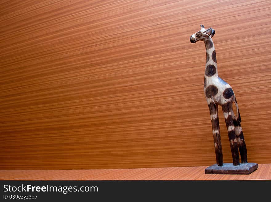 A giraffe handicraft with a wooden background. A giraffe handicraft with a wooden background