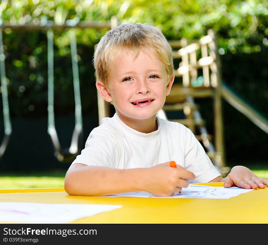 Cute boy poses and smiles outdoor while at preschool. Cute boy poses and smiles outdoor while at preschool