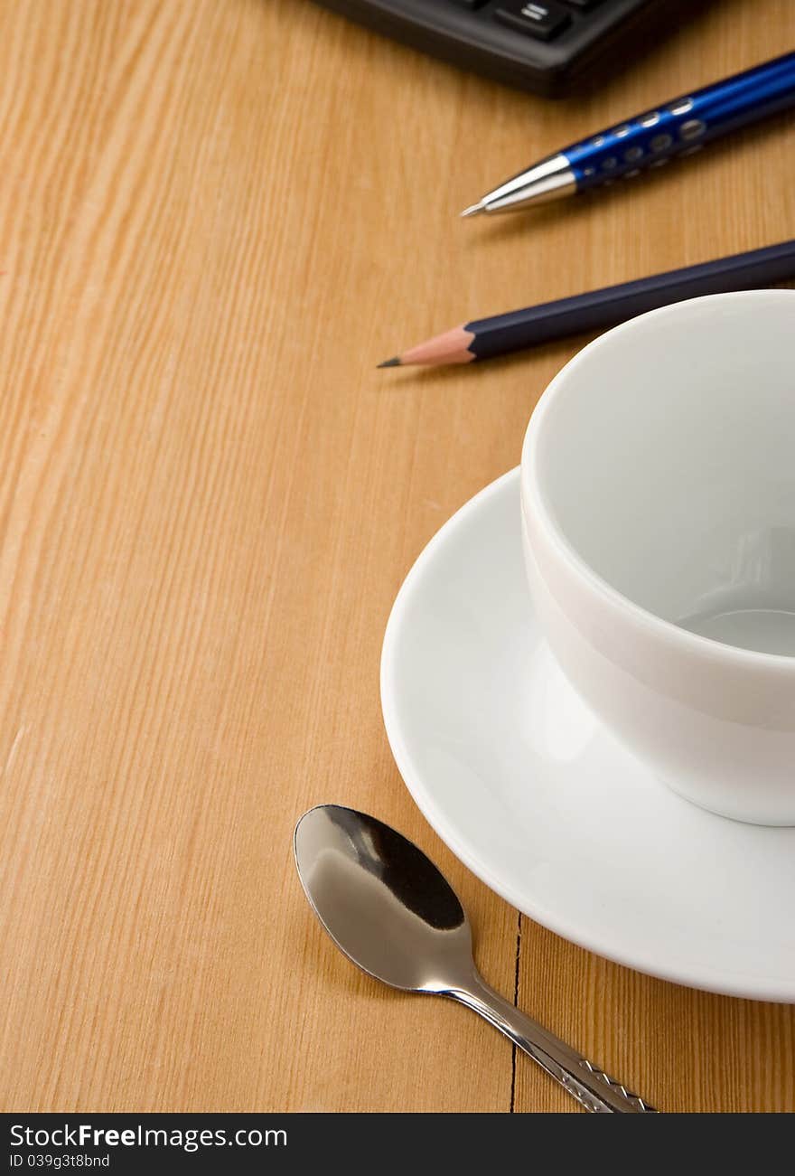 Pen, calculator and cup of coffee on wooden table