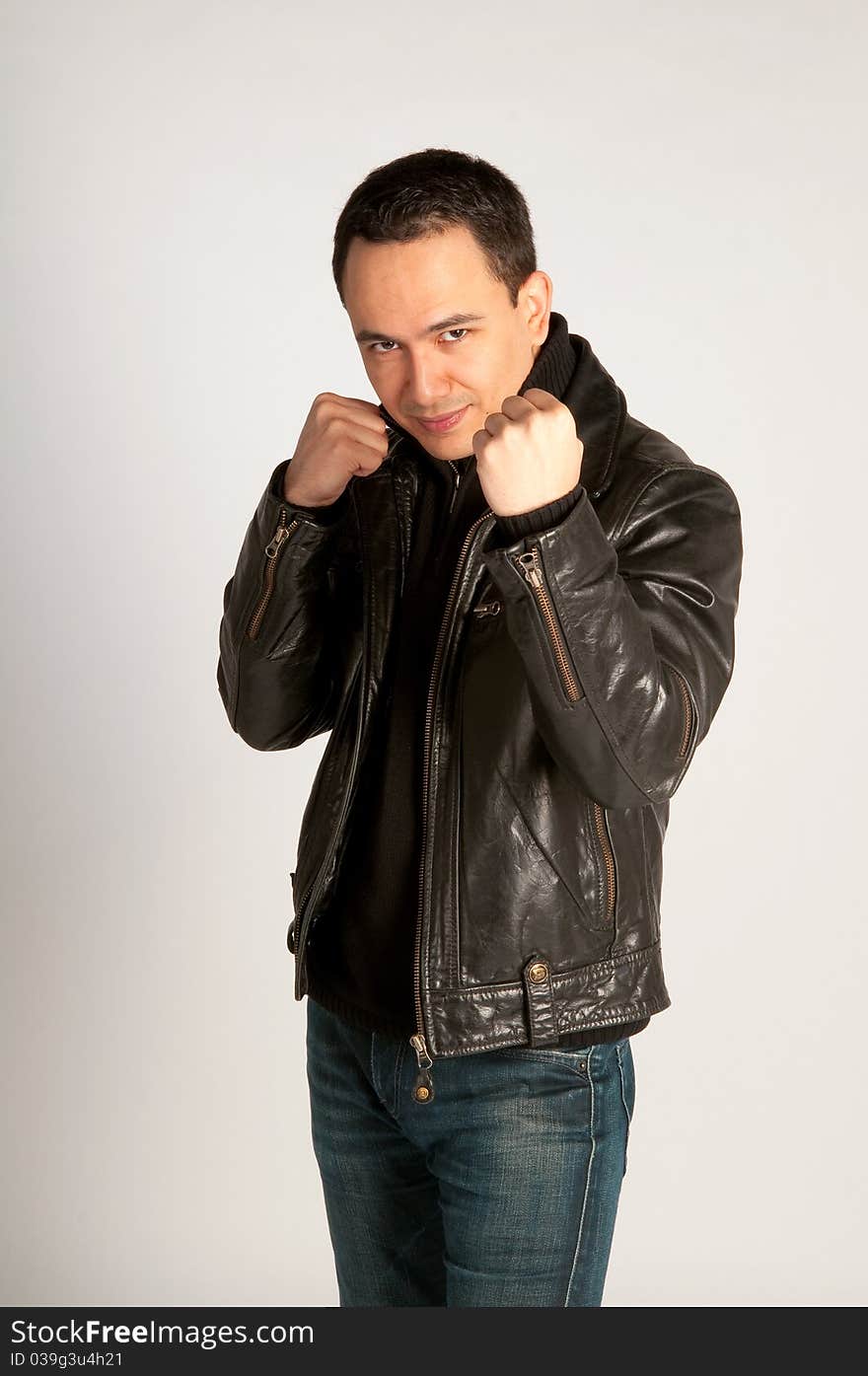 Tough attractive man in fighting pose in black leather jacket on white background isolated. Tough attractive man in fighting pose in black leather jacket on white background isolated