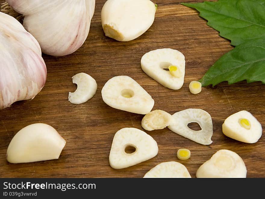 Set of garlic and green leaves on wood