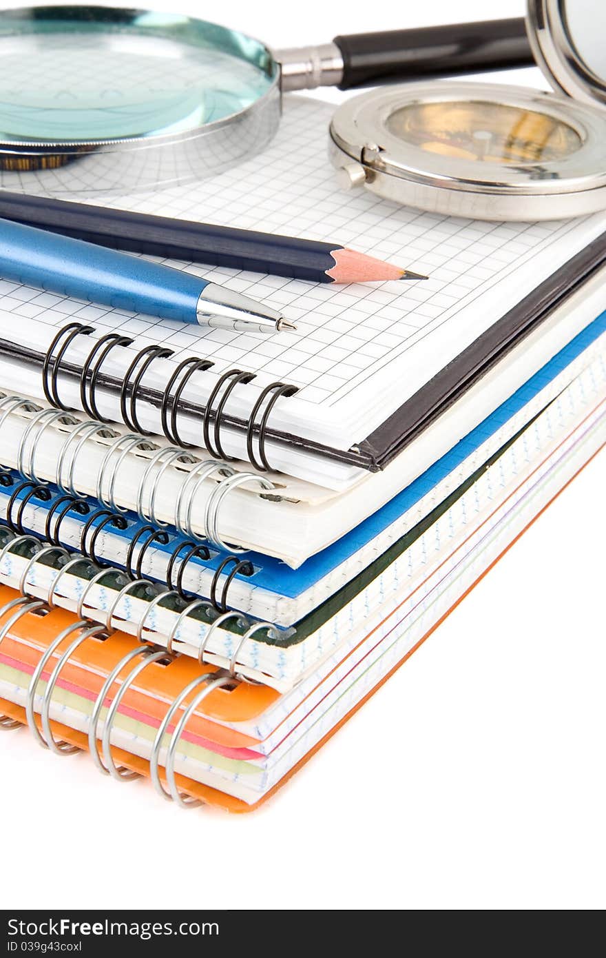 Pen and pencil at pile of notebook isolated on white background. Pen and pencil at pile of notebook isolated on white background