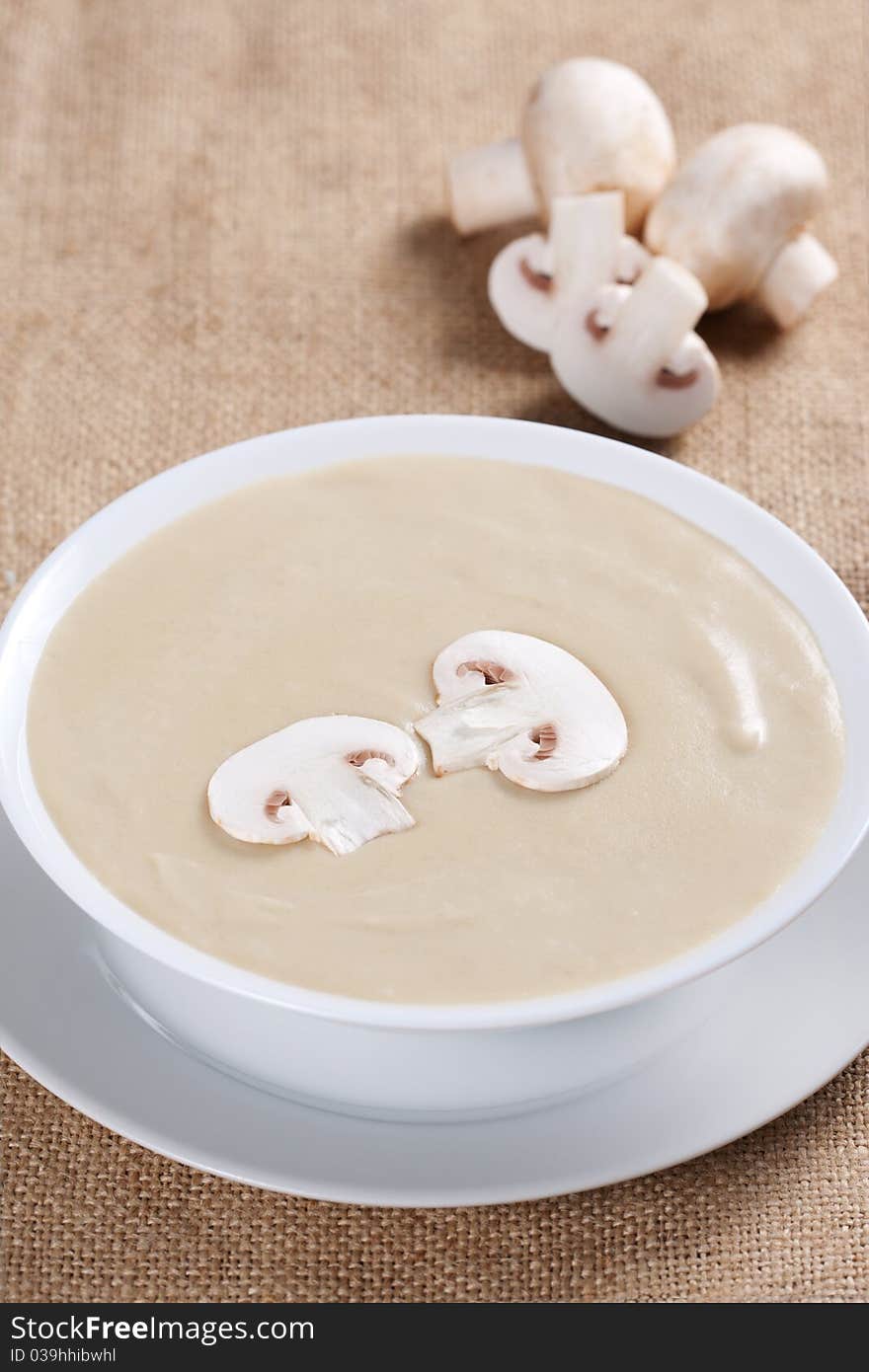 Bowl of mushroom soup with fresh mushrooms and parsley