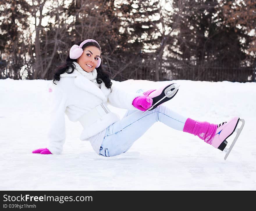 Beautiful young brunette woman ice skating outdoor