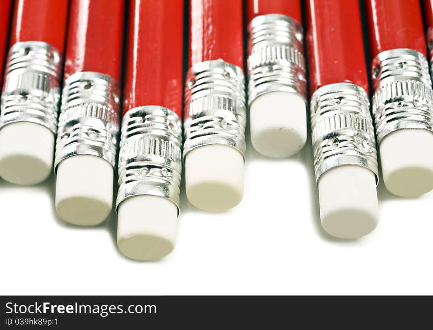 Close up macro o red pencils with white erasers on a white background with space for text