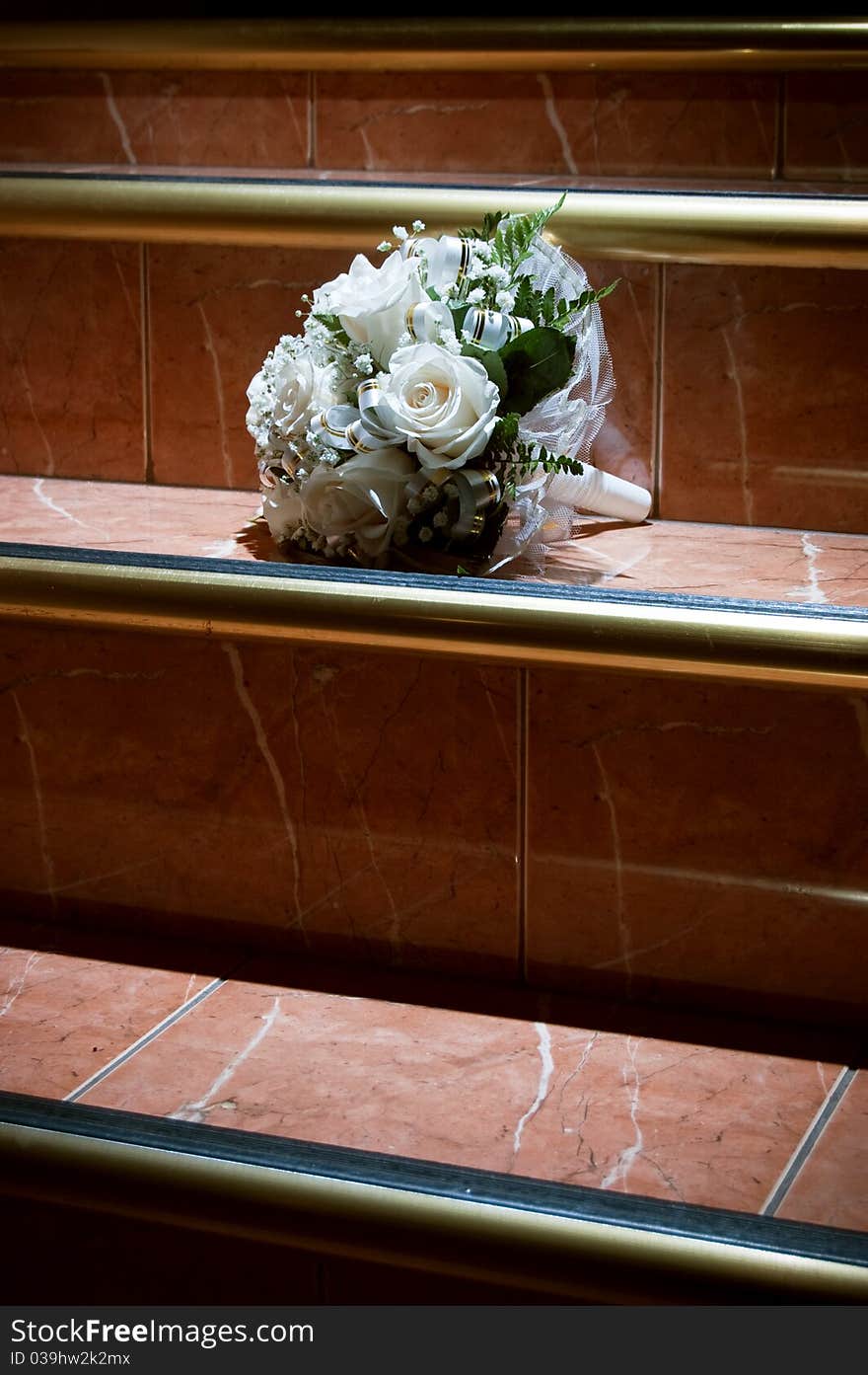 Wedding bouquet from white roses on the stairway