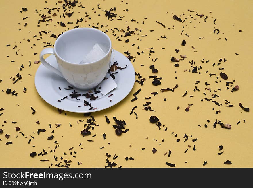 Some tea leaves with a tea cup. Some tea leaves with a tea cup