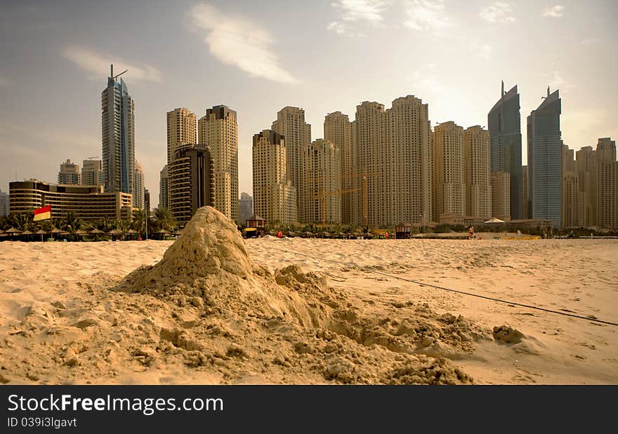 Beach with sandy bilding on the modern city background. Beach with sandy bilding on the modern city background