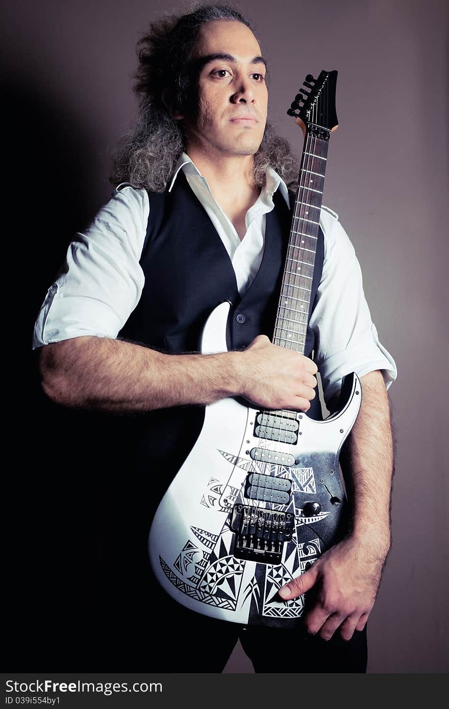 Man with guitar with dark background. Man with guitar with dark background.