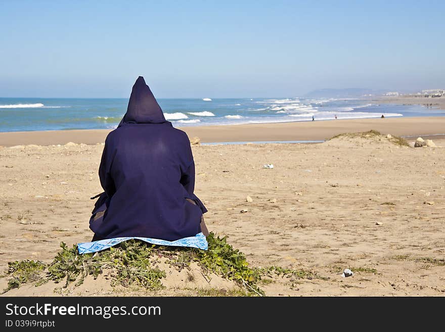 Traditionaly dressed moroccan man relaxing at the atlantic beach. Traditionaly dressed moroccan man relaxing at the atlantic beach