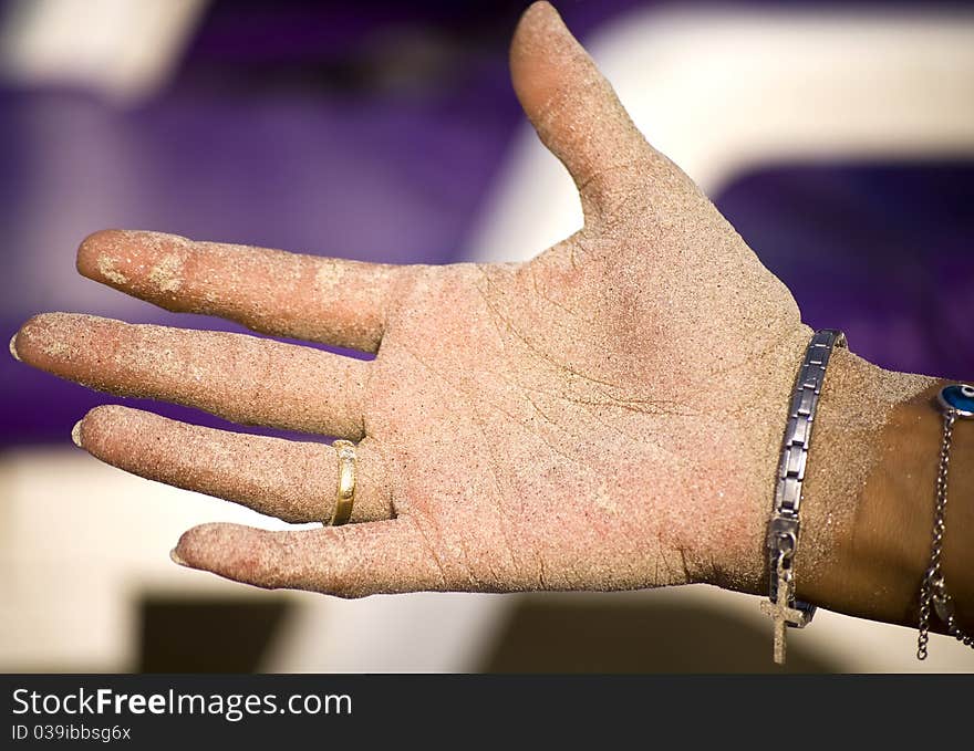 A girls hand full covered with sand from the beach. A girls hand full covered with sand from the beach