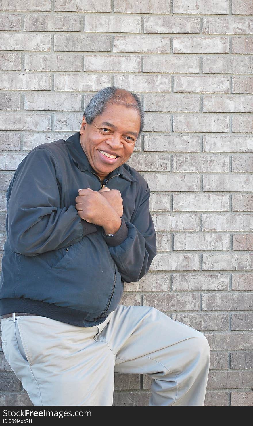 Expressions of an african american male standing against a wall outdoors. Expressions of an african american male standing against a wall outdoors.