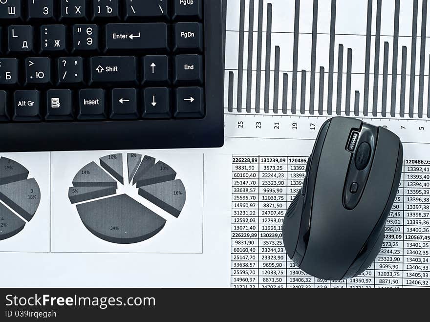 Black keyboard and mouse on a stock chart. Black keyboard and mouse on a stock chart.