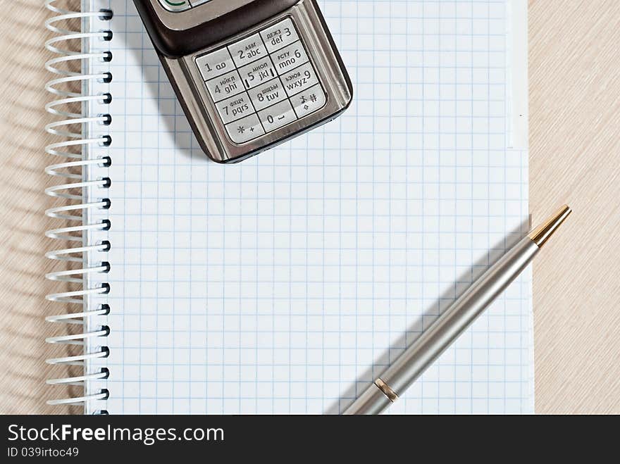 Mobile phone, notepad and pen on wood desk. Mobile phone, notepad and pen on wood desk