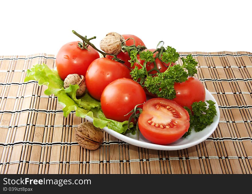 Bunch of tomatoes and lettuce on the surface of woven straw