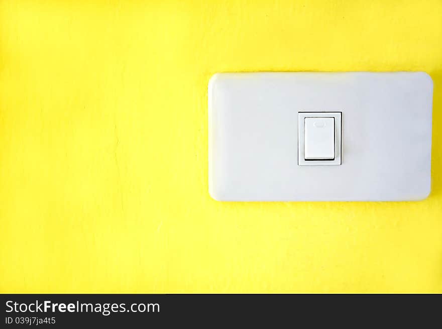 Light switch on yellow wall.